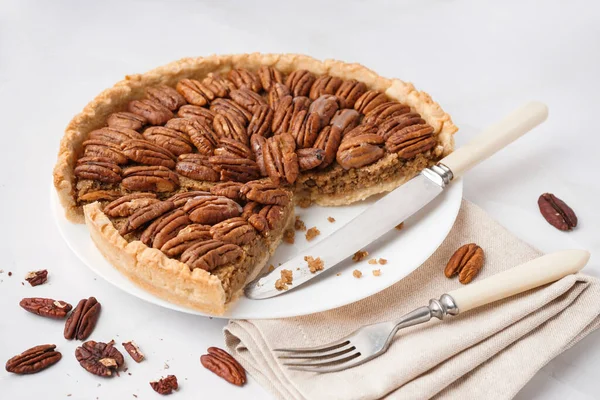 Plate with tasty pecan pie on white background