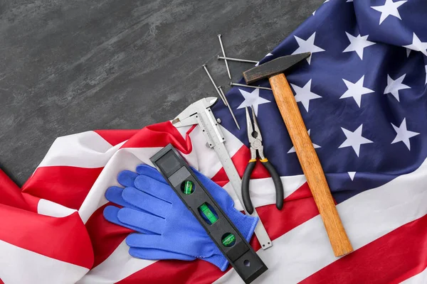 Different tools and USA flag on black grunge background. Labor Day celebration