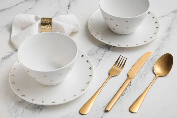 精美的餐桌布置 白色大理石背景上有金色餐具和折叠式餐巾 — 图库照片