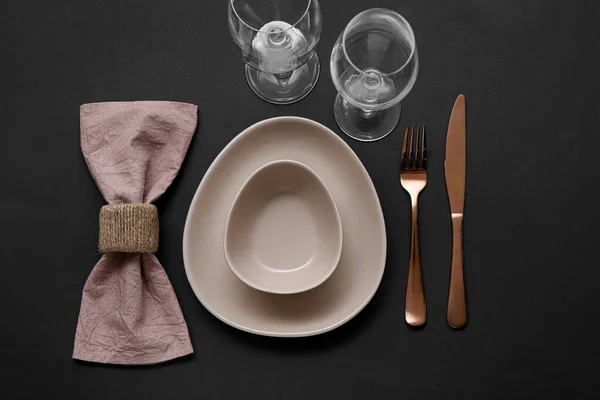 精致的餐桌 配有玫瑰色金制餐具和折叠式餐巾 背景为褐色 — 图库照片