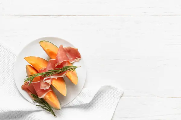 Plaat Van Heerlijke Meloen Met Prosciutto Rozemarijn Witte Houten Achtergrond — Stockfoto