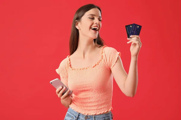 Счастливая Молодая Женщина Кредитными Картами Мобильный Телефон Красном Фоне — стоковое фото