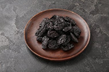 Siyah arka planda lezzetli kurutulmuş erikli tabak.