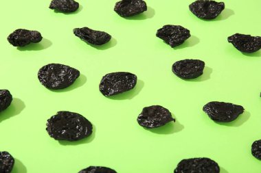 Yeşil arka planda lezzetli kurutulmuş erikler.