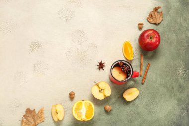 Arkaplanda elma ve portakallı sıcak şarap.