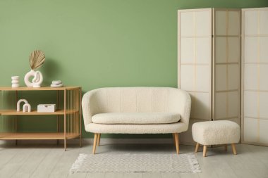 Şık halısı, beyaz kanepesi ve puf olan oturma odasının içinde.