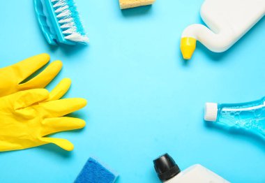 Mavi arka planda ev temizleme malzemelerinden yapılmış çerçeve