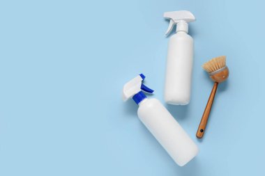 Mavi arka planda deterjan ve fırça şişeleri