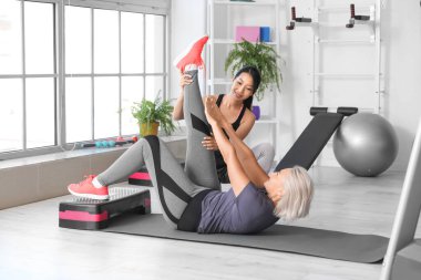 Rehabilitasyon merkezinde terapist eğitimi almış olgun bir kadın.