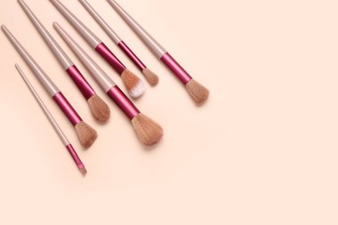 Pembe arka planda farklı makyaj fırçaları