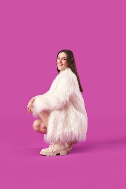 Mor arka planda kürklü genç bir kadın.