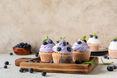 Beyaz arka planda yabanmersinli ve naneli lezzetli keklerden oluşan ahşap tahta bir tahta.