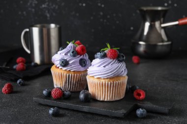 Böğürtlenli, ahududulu ve siyah arkaplanlı lezzetli kekler.