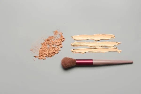 Makeup Borste Med Ansiktspulver Och Prover Foundation Grå Bakgrund — Stockfoto