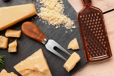 Masada lezzetli parmesan peyniri parçaları olan tahta, yakın plan.