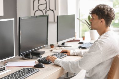 Ofiste bilgisayarla çalışan erkek programcı