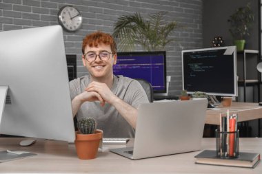 Ofiste bilgisayarla çalışan erkek programcı