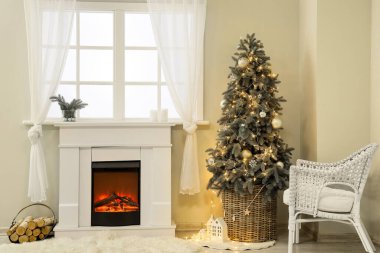 Pencerenin yanında şöminesi ve Noel ağacı olan şenlikli bir oturma odası.