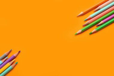 Sarı arkaplanda renkli kalemler grubu