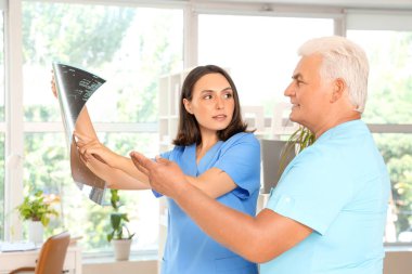 Doktorlar klinikte röntgen taramasını tartışıyor.