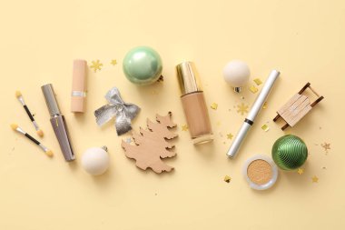 Dekoratif kozmetik ürünleri ve bej arka planda Noel dekoru olan kompozisyon