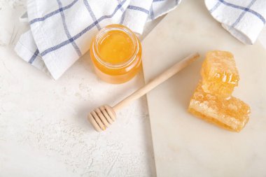 Bir kavanoz taze bal, dipper ve hafif arkaplanda taraklar