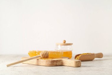 Tatlı bal petekleri ve arka planda arı poleni olan ahşap tahta.