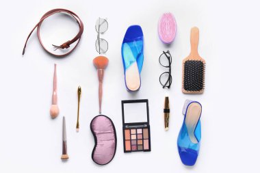 Beyaz arka planda farklı kadın aksesuarları, ayakkabıları ve kozmetik ürünleri olan kompozisyon