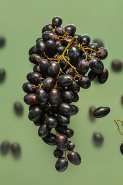 Yeşil arka planda uçan siyah üzümler