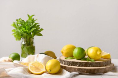 Beyaz fayans masasında limonata hazırlamak için malzemeler içeren ahşap tahta tahta.