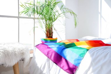 Işık odasındaki yatakta LGBT bayrağı