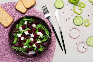 Beyaz arka planda pancar, kraker ve malzemelerle taze sebze salatası.