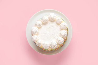 Pembe arka planda lezzetli doğum günü pastası olan tabak.