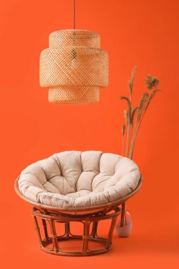 Çimenli yumuşak koltuk ve kırmızı arka planda asılı lamba