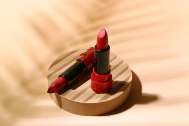 Bej arka planda farklı kırmızı rujlarla dur