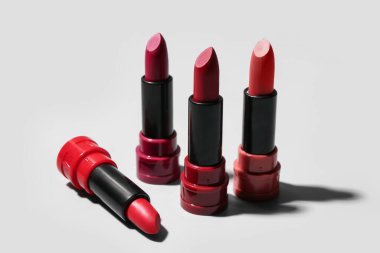 Aydınlık arkaplanda farklı yeni tarz rujlar, yakın plan.