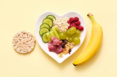 Bej arka planda taze sağlıklı ürünlerle dolu bir tabak. Diyet kavramı