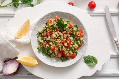 Lezzetli tabakta salata ve açık beyaz arka planda limon.