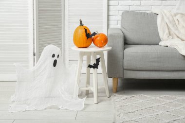 Cadılar Bayramı balkabakları ve kağıt yarasalarla dolu bir masa.