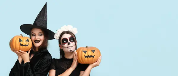 Jonge Vrouwen Gekleed Voor Halloween Holding Pompoenen Lichtblauwe Achtergrond Met — Stockfoto