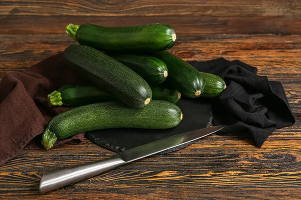 Black Board Many Fresh Zucchini Knife Brown Wooden Background — Stock Photo, Image