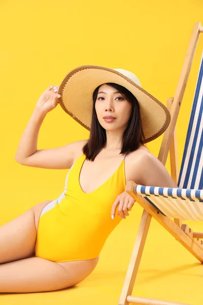 Hermosa Mujer Asiática Sentada Junto Silla Cubierta Sobre Fondo Amarillo — Foto de Stock
