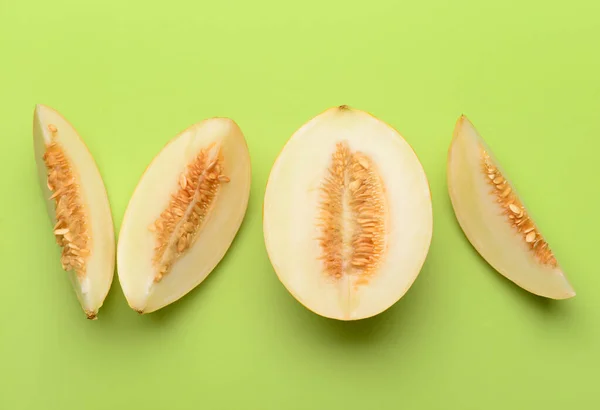 Pieces of sweet melon on green background