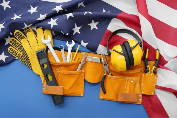 青い背景にさまざまなツール 米国旗でベルト 労働者の日のお祝い — ストック写真
