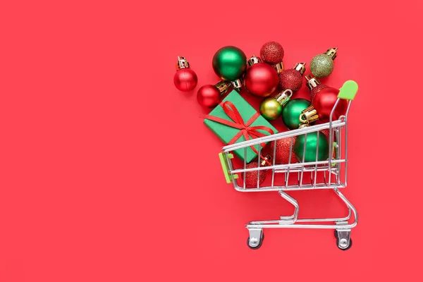 Liten Kundvagn Med Julbollar Och Presentförpackning Röd Bakgrund — Stockfoto