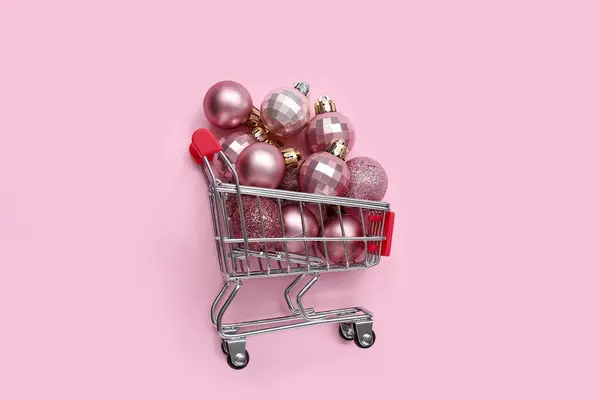 Carrinho Compras Pequeno Com Bolas Natal Diferentes Fundo Rosa — Fotografia de Stock