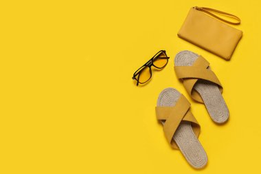 Çantalı ve güneş gözlüklü sarı sandaletler.