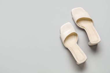 Gri arkaplanda şık beyaz sandaletler