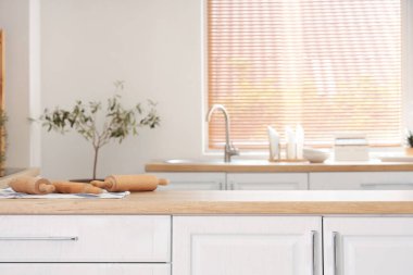 Beyaz tezgahlı aydınlık mutfak ve lavabo.