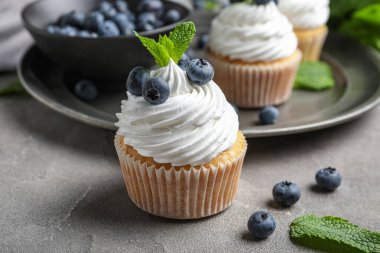 Yaban mersinli lezzetli kek ve gri arka planda nane şekeri.
